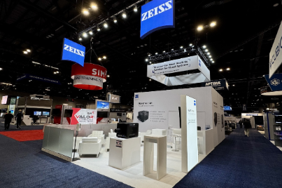 Custom 20' x 30' trade show booth for ZEISS at I/ITSEC in Orlando, featuring a minimalist white architectural design and integrated display zones for high-end optical technology.